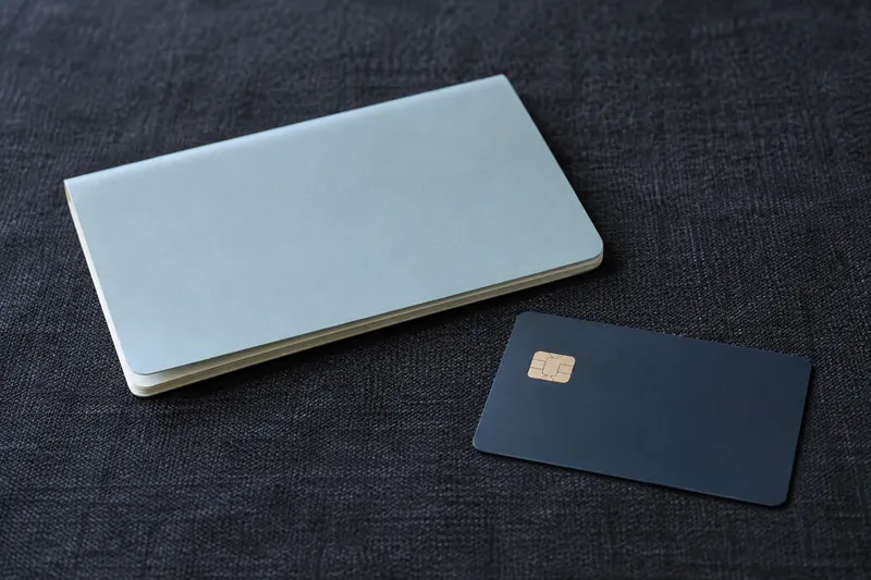 A closed passbook beside an unmarked payment card.